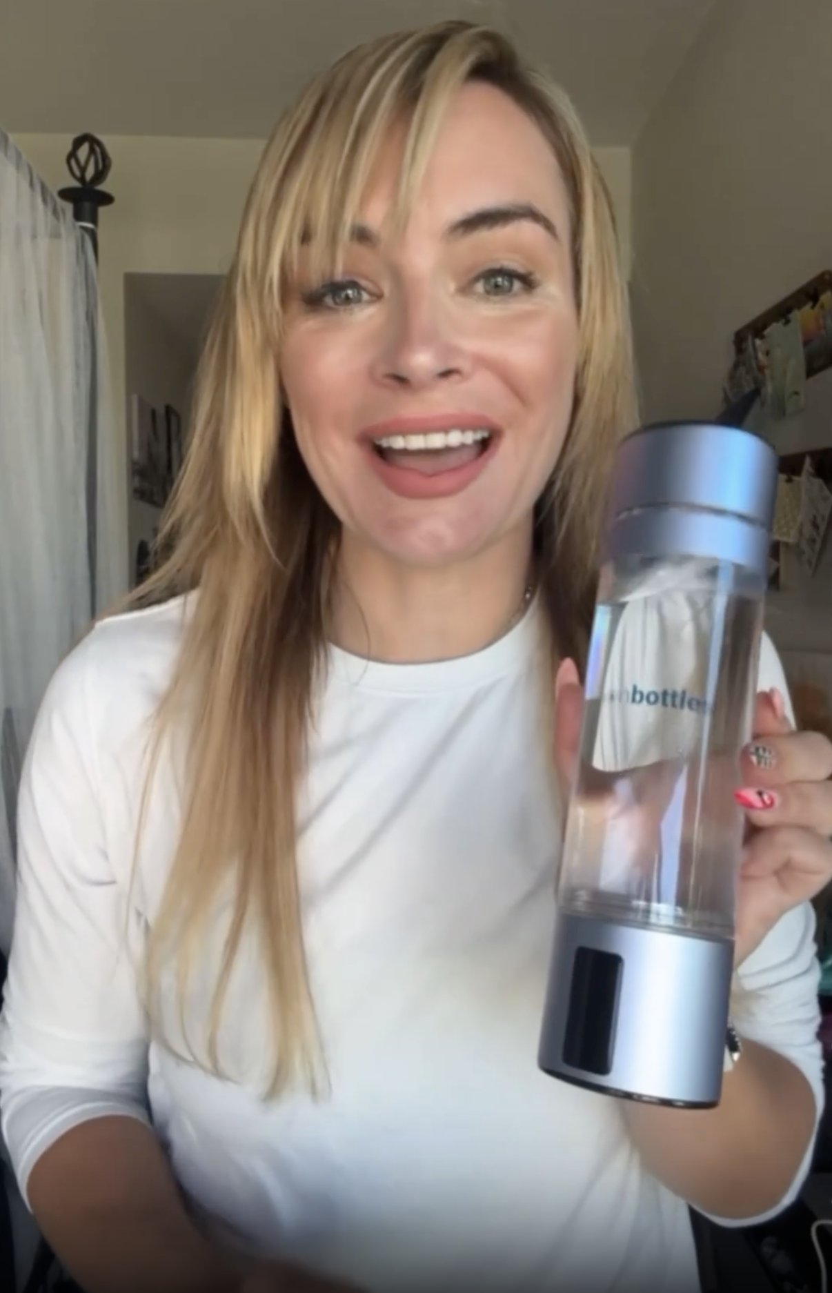 Customer smiling with the ATOM hydrogen water bottle at home